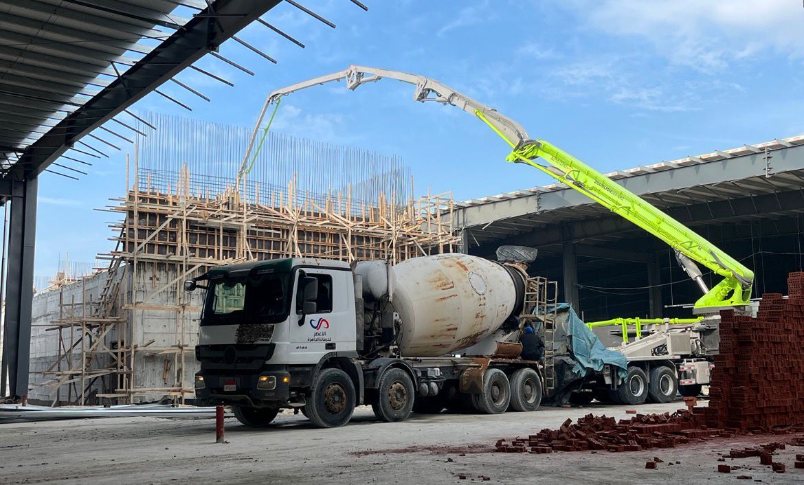 Concrete pump truck and construction crew on a steel-frame project