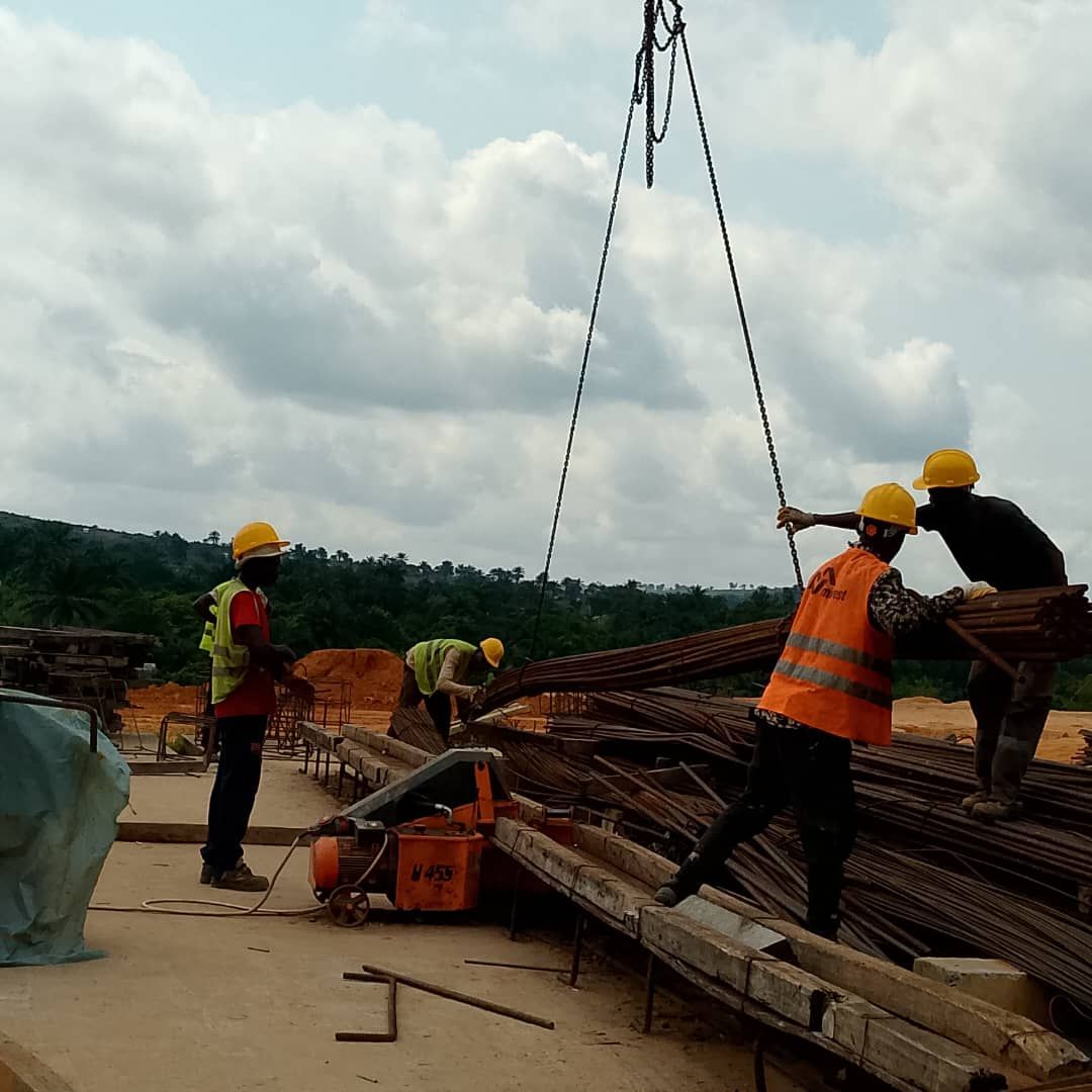 Construction labourers handling rebar bundles on site