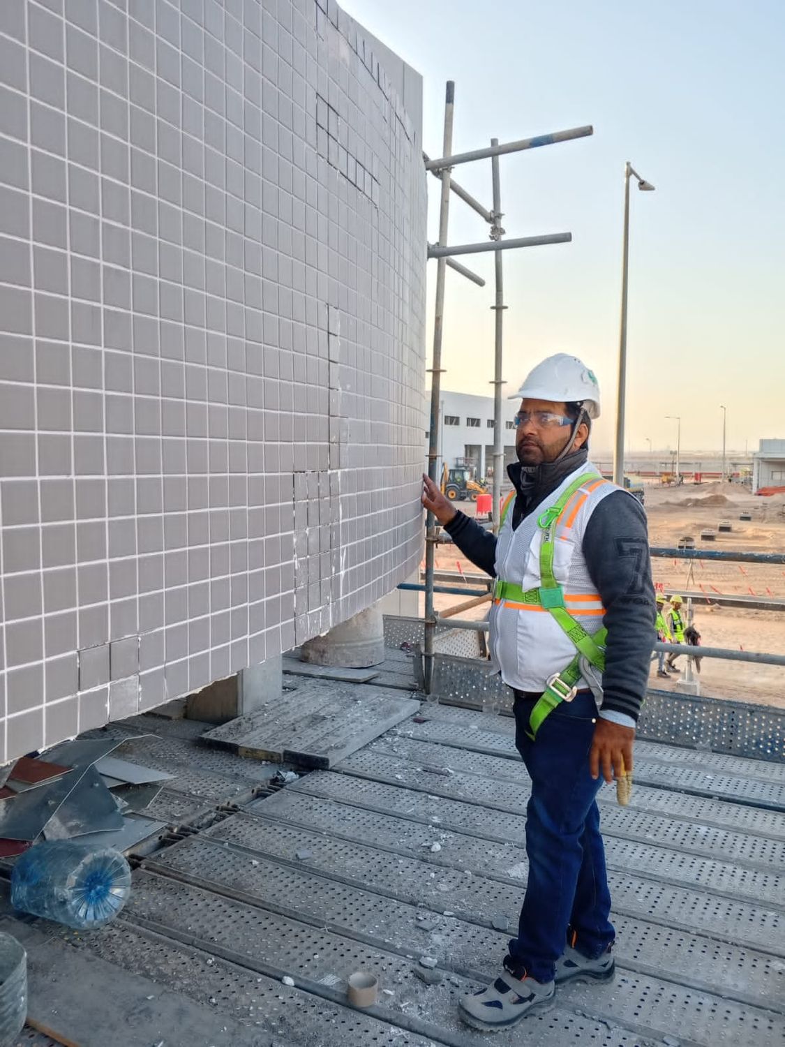 Worker installing facade cladding on a commercial building