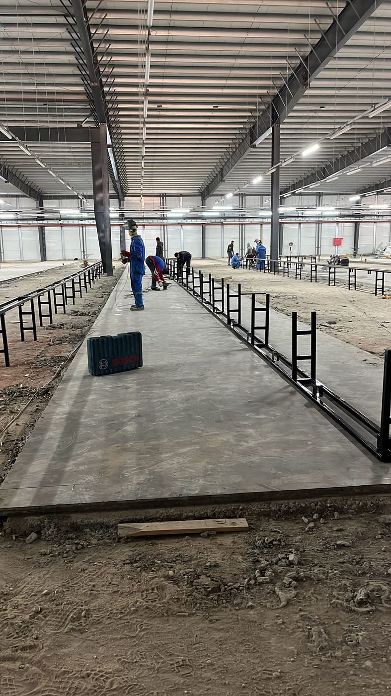 Welders installing floor screed rails