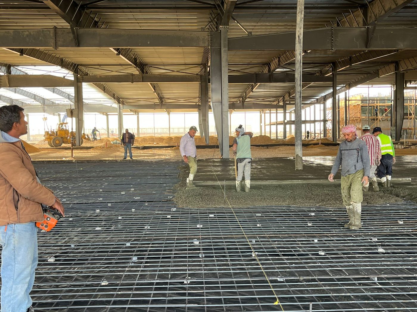 Crew levelling fresh concrete over mesh flooring